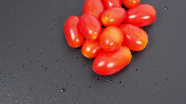 Close up group of Cherry Tomatoes on black background.