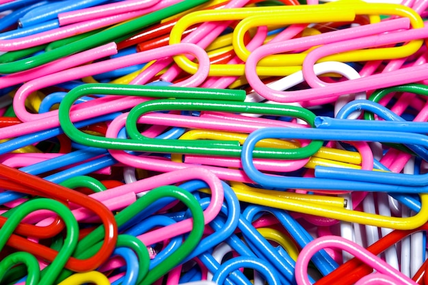 Photo close-up group of multicolored paper clips, a tool used for office and school