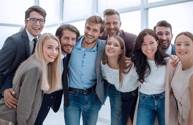 Foto primo piano gruppo di giovani sorridenti guardando la telecamera