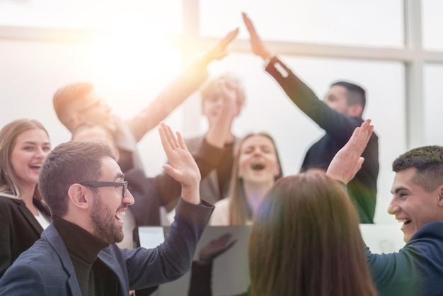 close up. a group of young business people giving each other a high five