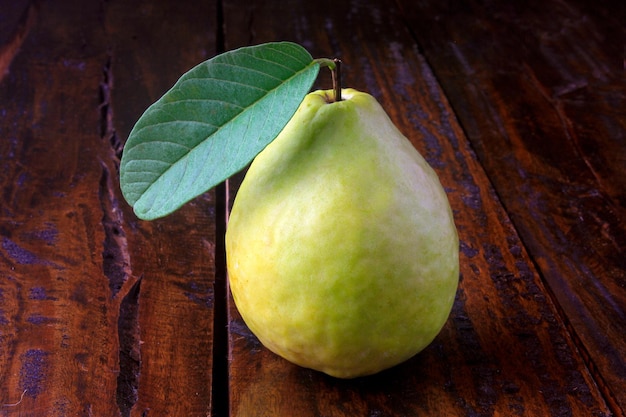 Foto close-up guava vrucht roze vers biologisch met bladeren heel en gesneden op rustieke houten tafel