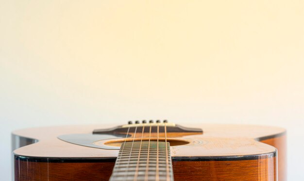 Close-up of guitar against beige background