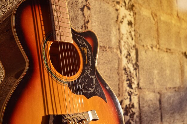 Foto close-up di una chitarra contro il muro