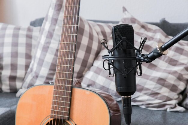 Photo close-up of guitar with microphone against sofa