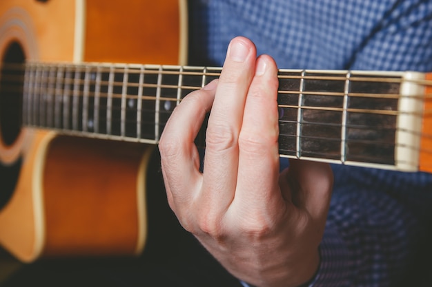 Chiuda in su della mano del chitarrista che gioca la chitarra