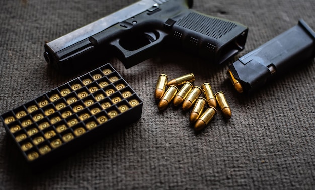 Close-up of gun with bullets on table