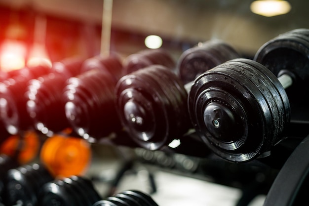 Foto primo piano di attrezzature da palestra pesanti bilancieri in piedi su un supporto