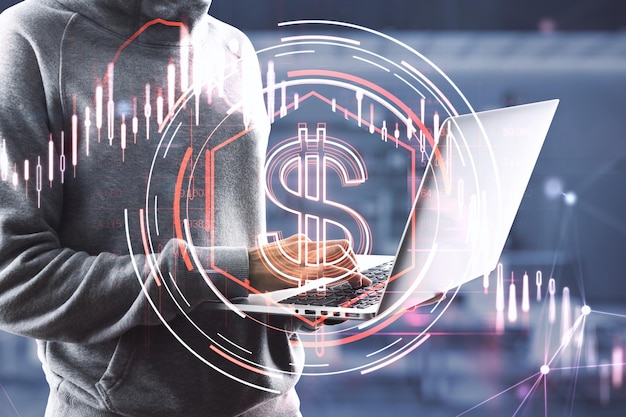 Close up of hacker hands using laptop computer with downward red dollar candlestick chart on blurry office interior background financial crisis hacking and recession concept double exposure