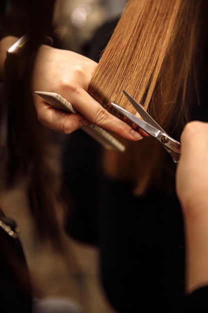 Foto primo piano del parrucchiere che taglia i capelli dei clienti nel salone di bellezza che taglia i capelli con le forbici