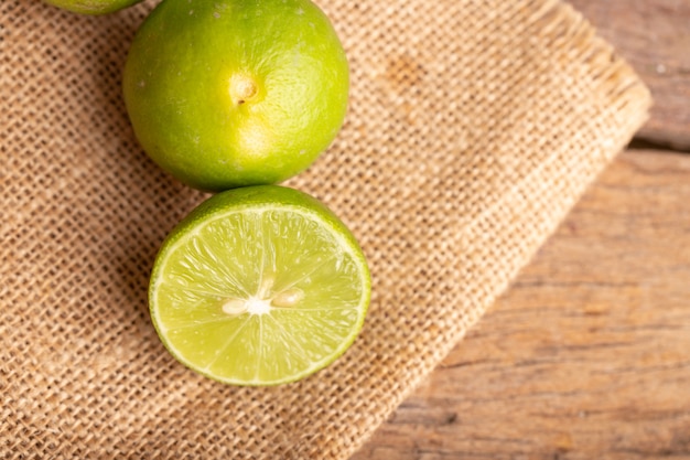 Close up a half of the green lime and seed place on the woven sack