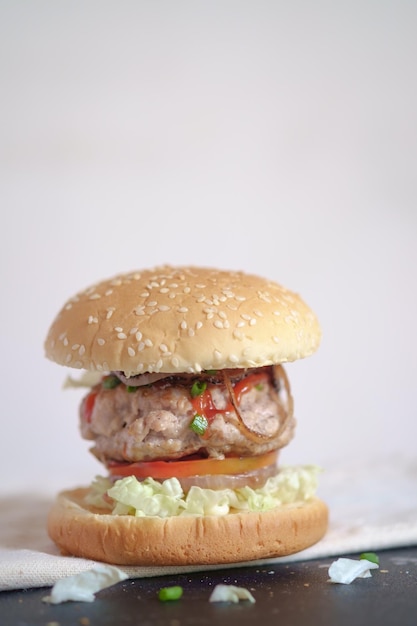 Foto close-up di un hamburger sul tavolo contro una parete bianca
