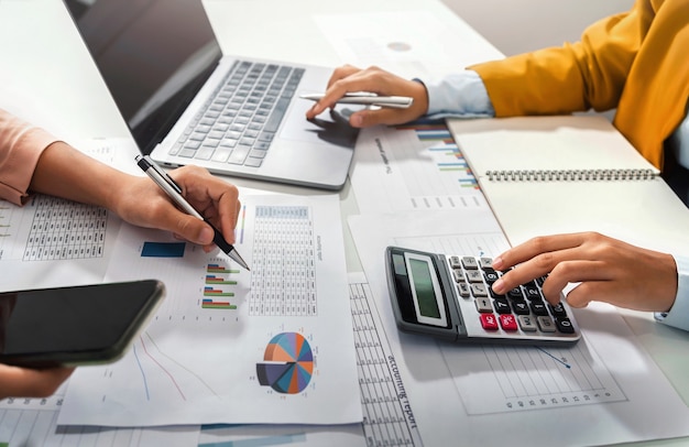 Close up hand accountant holding pen pointing on paperwork chart for meeting team in office room. concept finance and accounting