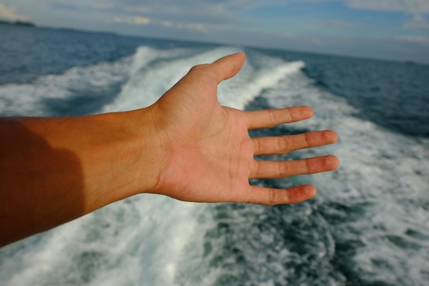 Photo close-up of hand against sea