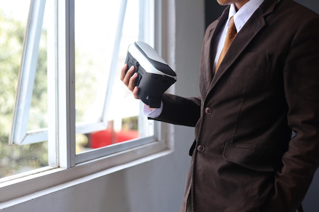 Close-up hand of businessman holding VR glasses at the office.