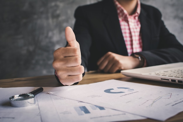 Close up hand of businesswoman thumb up with confidence on office background