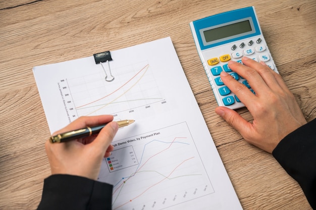 Close up hand of Businesswomann using calculationg machine household finances or taxes on machine, Finance and Accounting concepts,