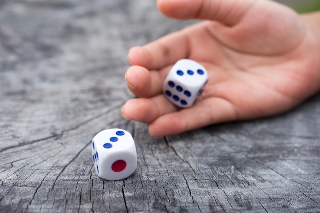 Photo close-up of hand by dice on wood