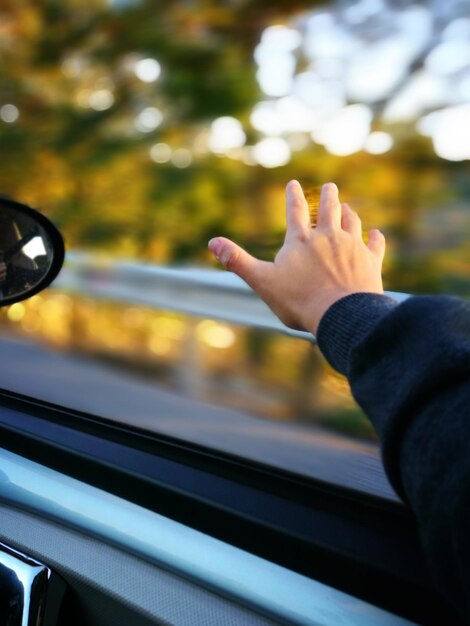 Foto close-up di una mano sul finestrino dell'auto