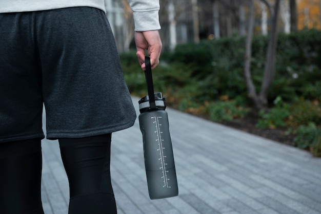 close up hand carrying water bottle