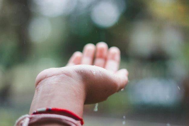 Foto close-up di una mano che cattura le gocce di pioggia all'aperto