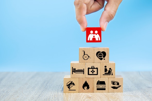 Close-up hand choose a red cube wooden toy blocks stacked in pyramid shape with family icon.