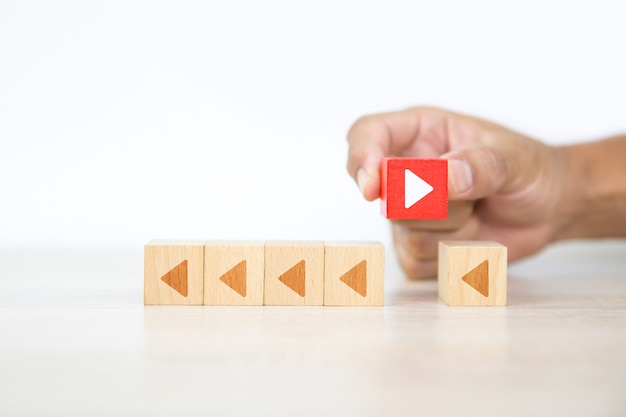 Close-up hand chooses arrow icon on cube wooden toy block stacked