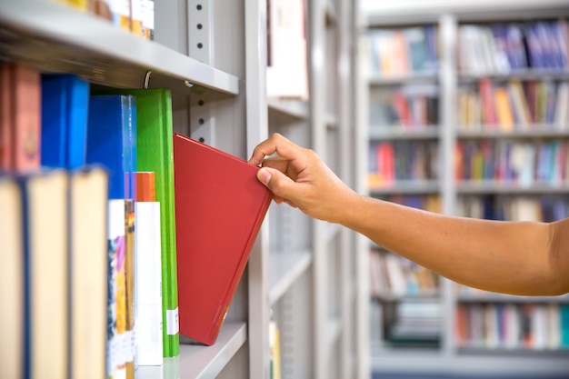 Chiudere la mano scegliendo un libro dallo scaffale.