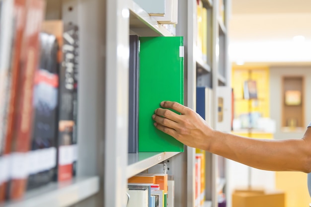 Chiudere la mano scegliendo un libro dallo scaffale.