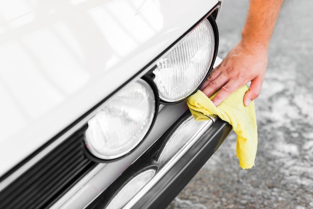 Photo close-up hand cleaning car with cloth