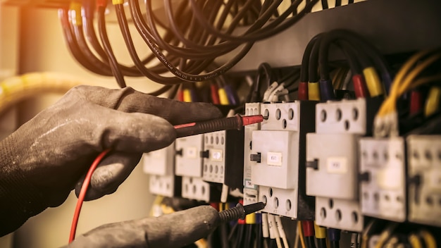 Close-up hand of electrical engineering using measuring to checking electricity.