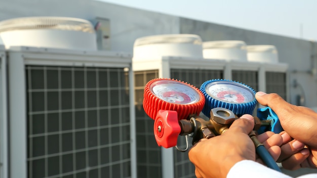 Close up hand of engineer using manifold gauge for filling air conditioners.