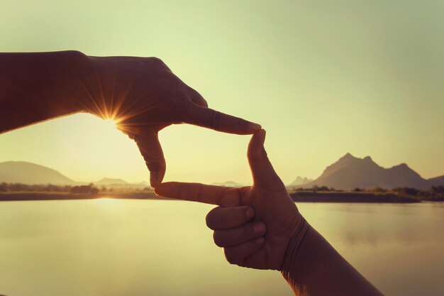 Close up hand framing looking view sunrise