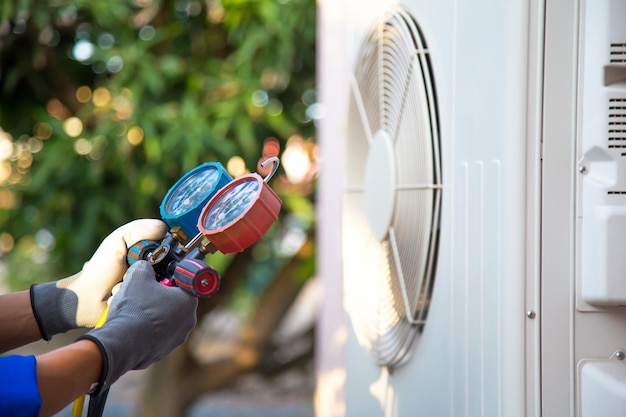 Close-up hand gebruik spruitstuk meter controleren koelmiddel airconditioner.