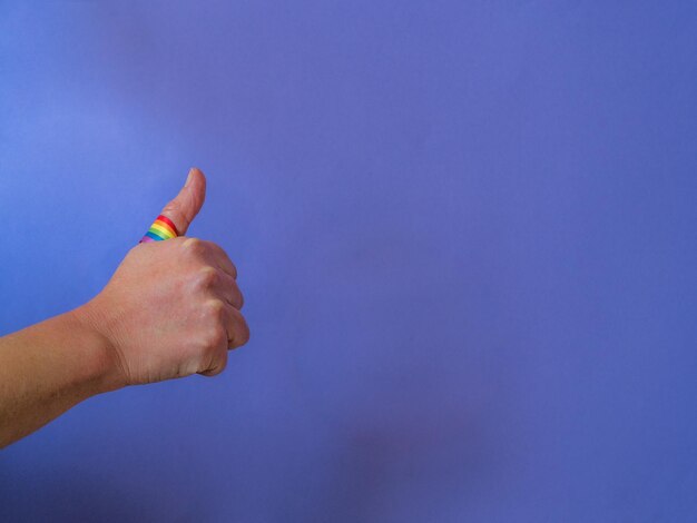 Photo close-up of hand gesturing against purple wall