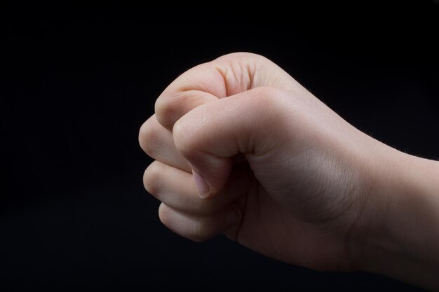 Close-up of hand gesturing over black background