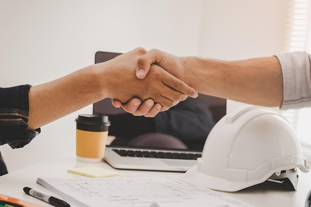 Close up hand of group, team young contractor, engineer handshake with partnership, customer after agreement to work together at the site, workplace, office. Business success concept.