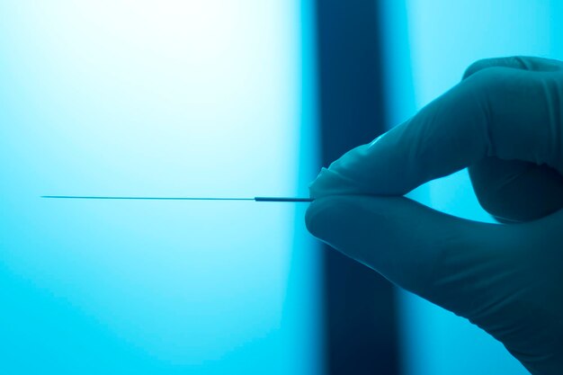 Close-up of hand holding acupuncture needle