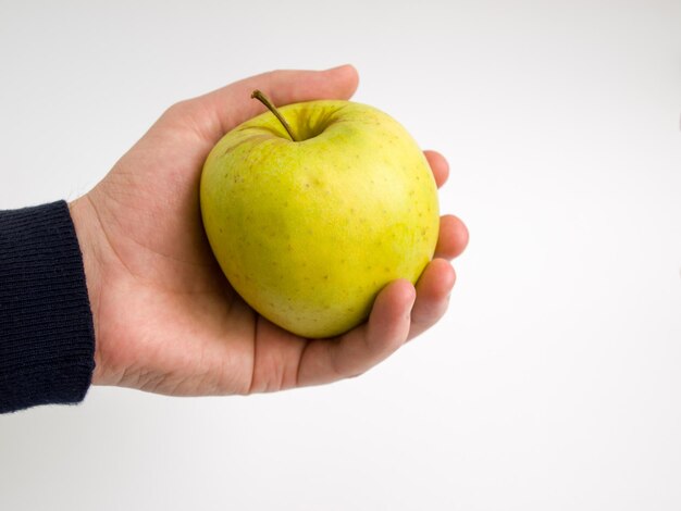 Photo close-up of hand holding apple