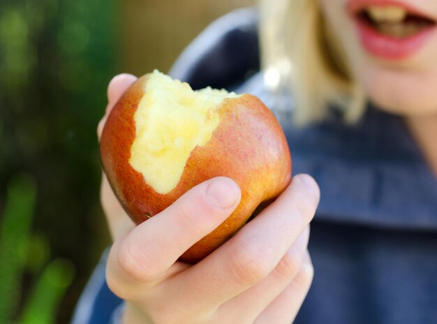 Photo close-up of hand holding apple