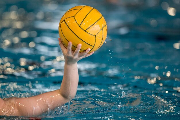 Close-up of hand holding ball with water splashing