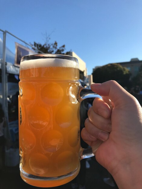 Close-up of hand holding beer glass