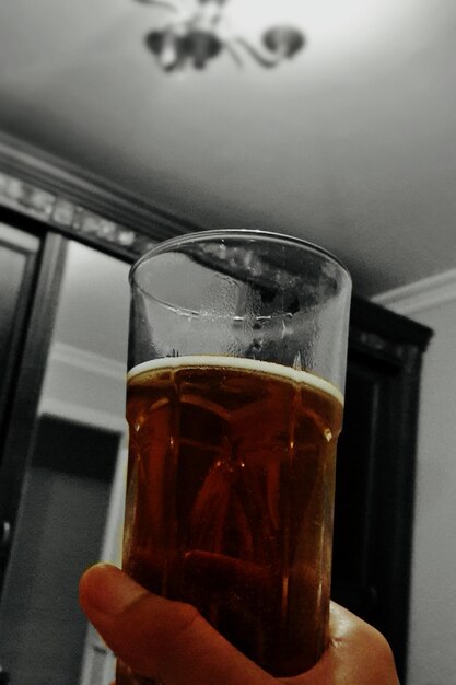 Close-up of hand holding beer glass