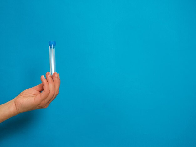 Close-up of hand holding blue background