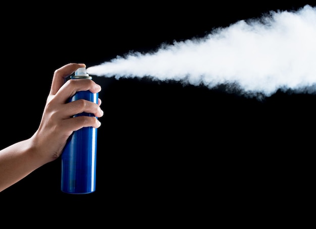 Photo close-up of hand holding bottle against black background