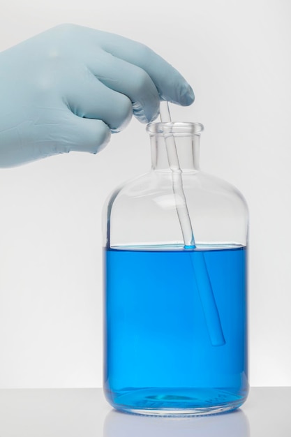 Close-up of hand holding bottle against white background