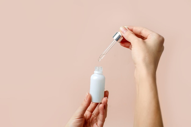 Close-up of hand holding bottle against white background