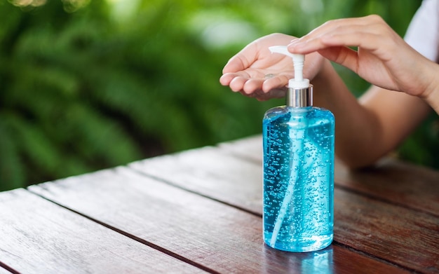 Photo close-up of hand holding bottle on table