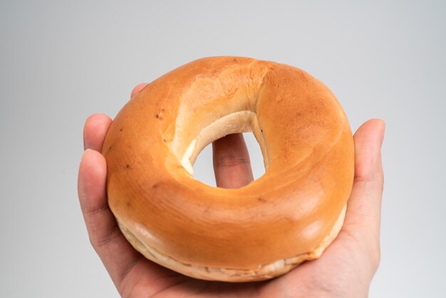 Close-up of hand holding bread against white background