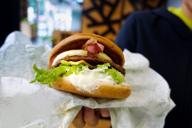 Photo close-up of hand holding burger