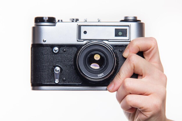 Photo close-up of hand holding camera against white background